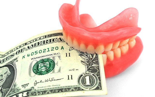 Full denture biting down on money