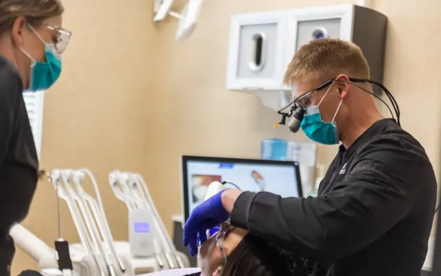 Dentist and dentistry team member talking to dental patient