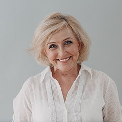 Older woman showing off new dentures