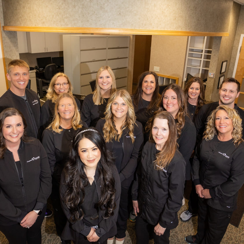 Chaska dentists and dental team standing outdoors in black clothing