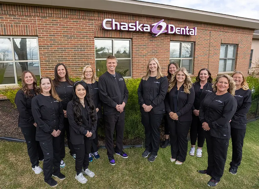 Chaska dentists and dental team standing outdoors in black clothing