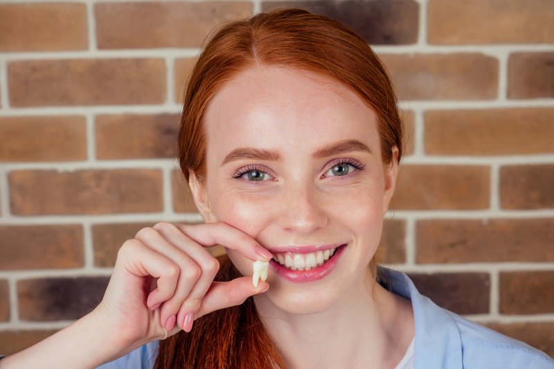 woman holding an extracted tooth